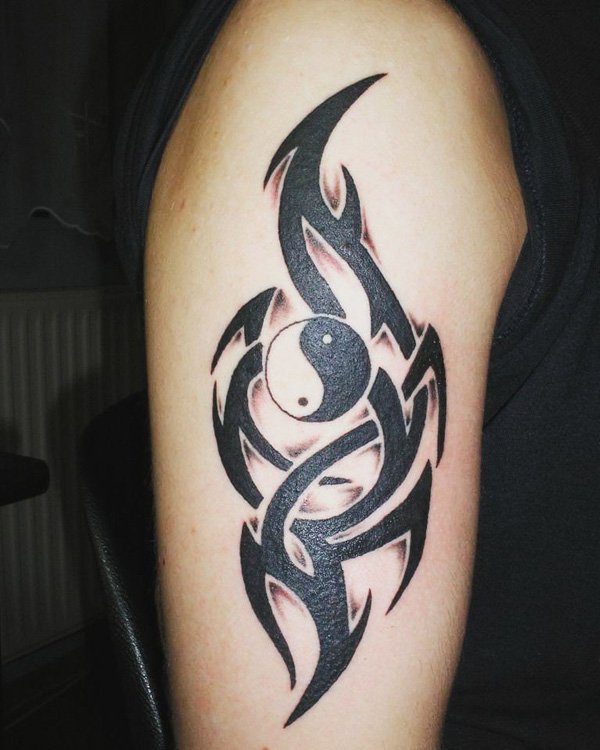 Yin Yang da tatuagem do símbolo armado com símbolos tribais. Esta é uma maneira maravilhosa de fazer o simples Yin Yang tatuagem destacam-se pela adição de complexo e surpreendente padrões tribais.