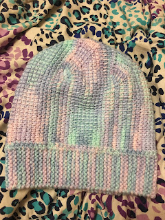 The finished hat laid flat. The contrast between the knitted garter stitch band and the Tunisian crochet body makes for an interesting distribution of the colors and textures.
