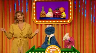 Chrissy Teigen tries to talk about fruit, when she is suddenly thrusted into competing against Gonger on Cookie Monster's Name That Fruit game show. Sesame Street Episode 5011, The Great Fruit Strike, Season 50.