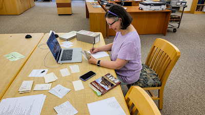 Susan seated at a table and doing research at the Wyominng State Archives