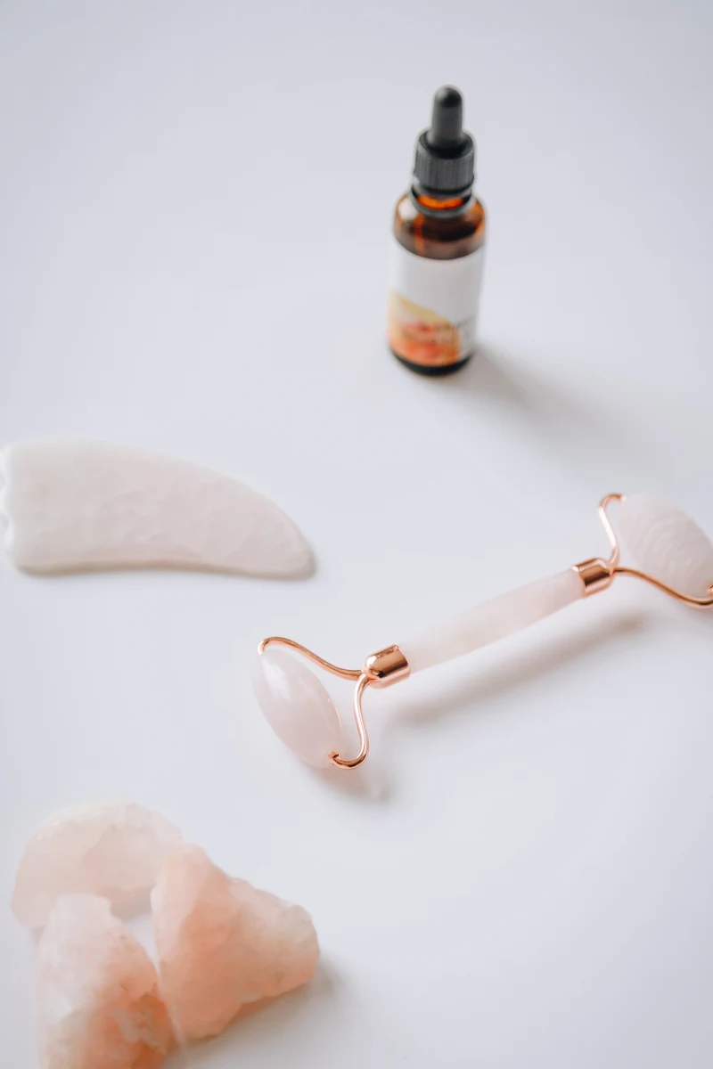 various skin care products and tools on top of a marble table