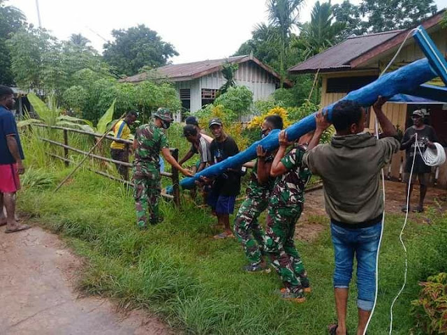 Satgas Yonif 125/Si’mbisa dan Warga Gotong Royong Pasang Tiang Listrik di Kampung Toray