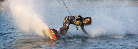 Performance: Close-up of man on wakeboarding reaching down to touch water
