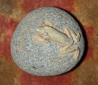 a stone frog on a pebble