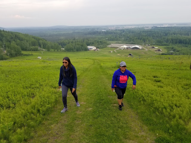 Ladies hiking up hill at night with daylight