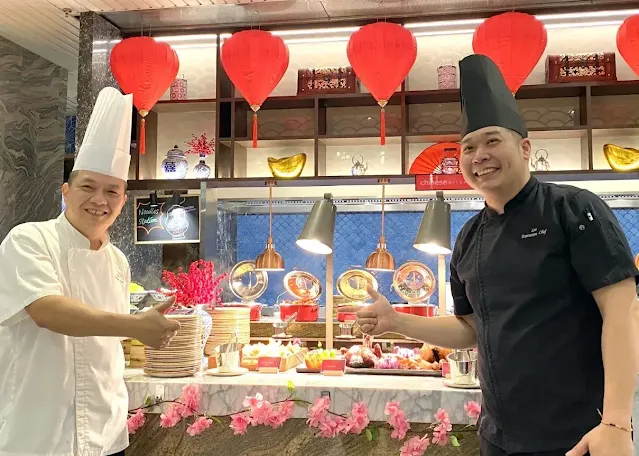two chinese chefs making a buffet