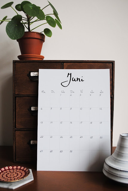 A4 met daarop de kalender van de maand juni gestyled met een houten kastje en keramieken vaasjes.