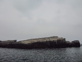 The cliff diving rock and surrounding waters of Long Dong snorkeling cove. 