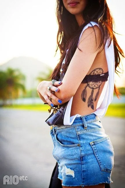 vemos a una linda mujer con un tatuaje de atrapasueños muy femenino