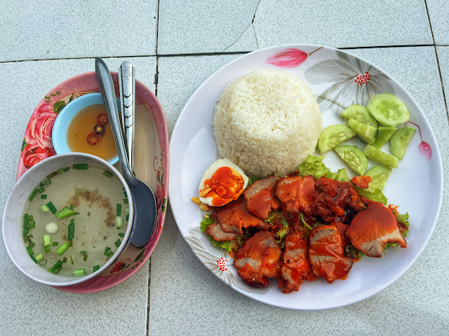 a plate of khao moo daeng served with rice and a bowl of broth in Savannakhet, Laos