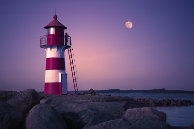 Immagine della luna sul mare con faro