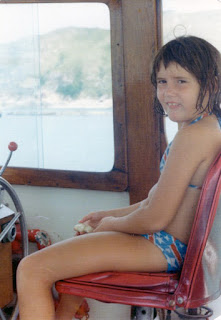 Charlotte as a child sitting on a boat