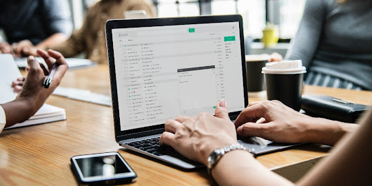 Affiliate marketer working on a computer with a smartphone on the table.