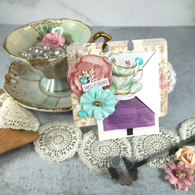 Heidi Swapp Memorydex Valentine's advent calendar made with the Prima With Love collection by Frank Garcia; vintage teacup die cut with a pocket of tea; decorated with ephemera, puffy stickers, paper flowers, lace trim and charms