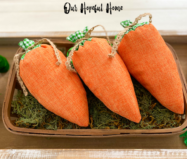 three orange burlap carrots in tobacco basket