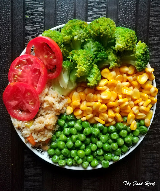 This vibrant vegan buddha bowl is filled with veggies like broccoli, peas, corns, tomatoes, served with brown rice and combined with a delicious, simple ginger and lime dressing.