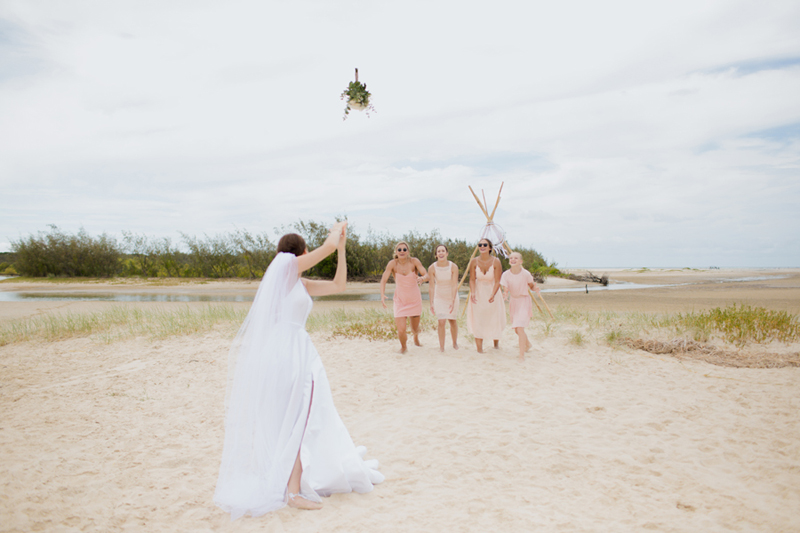 bride throws bouquet to bridesmaids