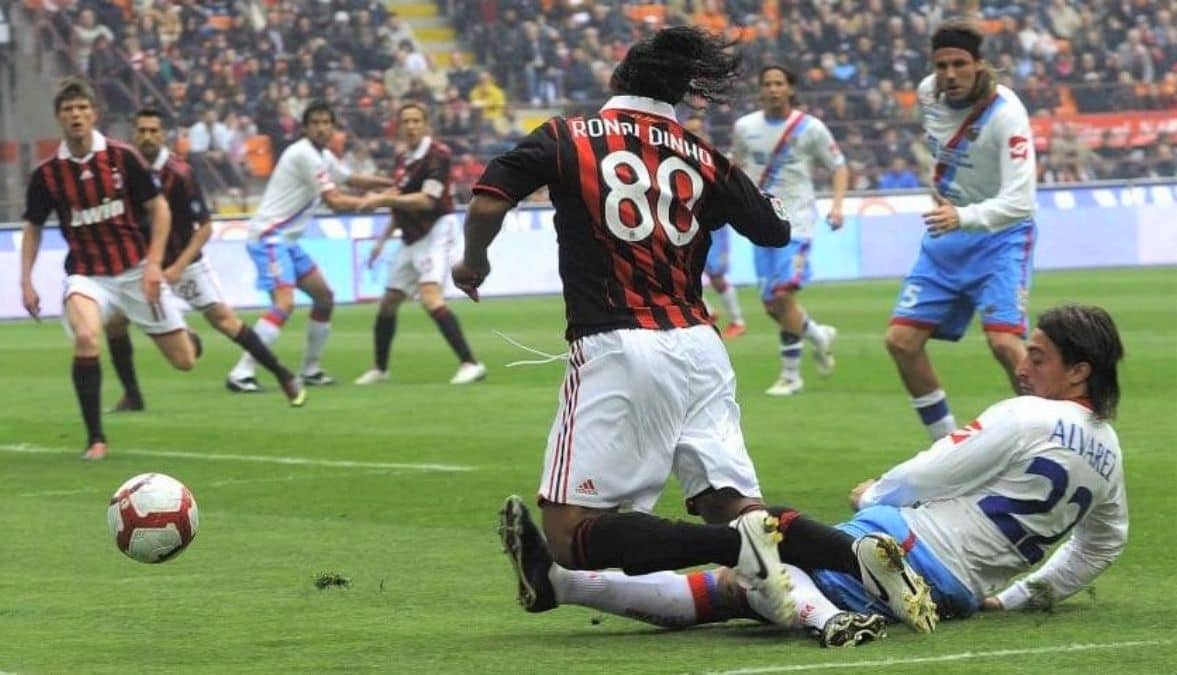 Ronaldinho intenta superar la fuerte marca de Pablo Álvarez.