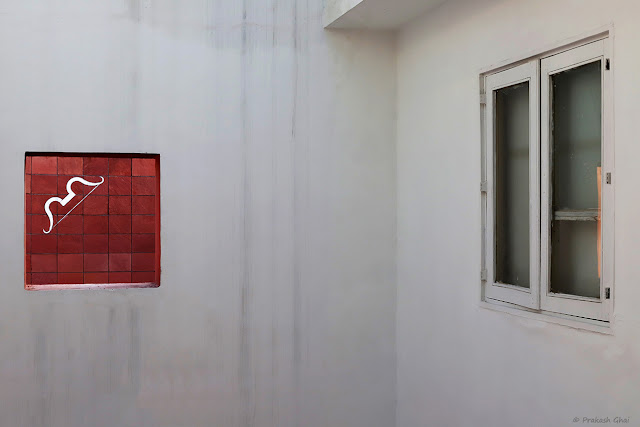 A Minimal Art Photograph of a White Bow on a Red Wall (Square) at Jawahar Kala Kendra, Jaipur.