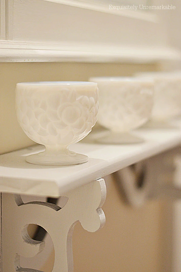 Footed Milk Glass Cups on a Shelf