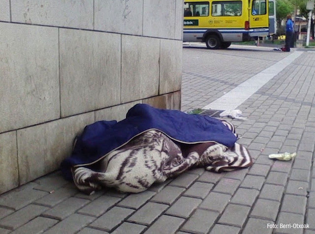 Una persona duerme en la calle junto al parque de Los Hermanos