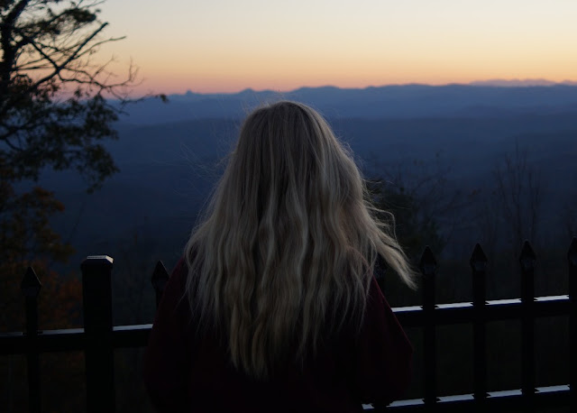 standing at the edge of the blue ridge mountains at sunset