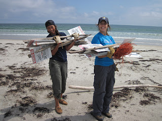 Image of interns with signs warning beach-goers of piping plover bird nests.