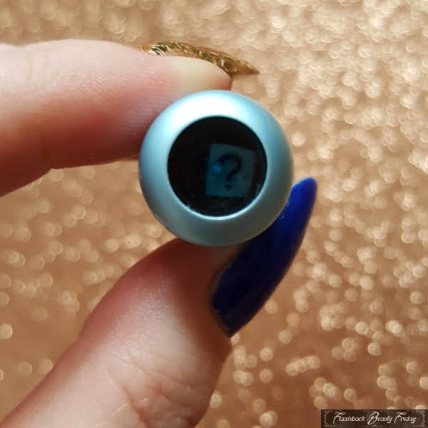close up of fortune telling lipgloss lid with question mark