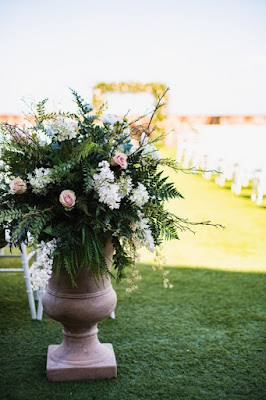 planter box in the front of wedding aisle with greenery and pink + white flowers