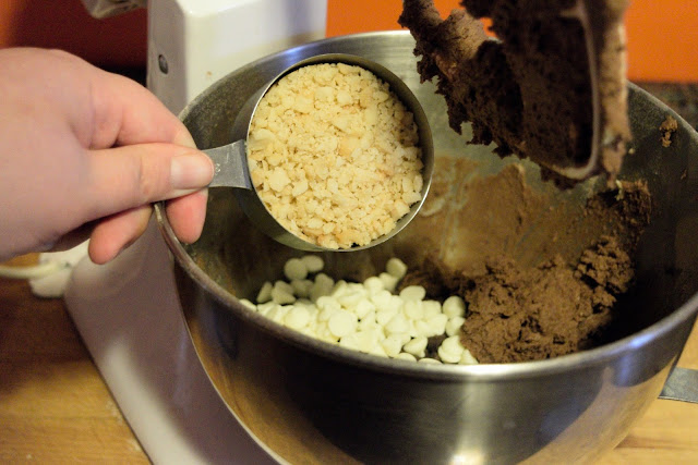 The chopped macadamia nuts being added to the cookie dough.