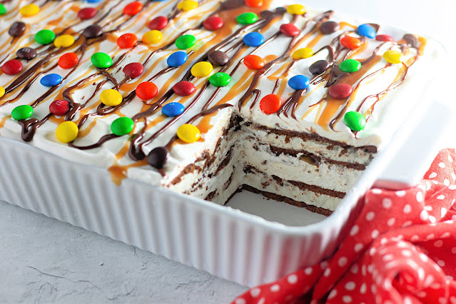 Ice Cream Sandwich Cake in a white dish with a piece cut out.