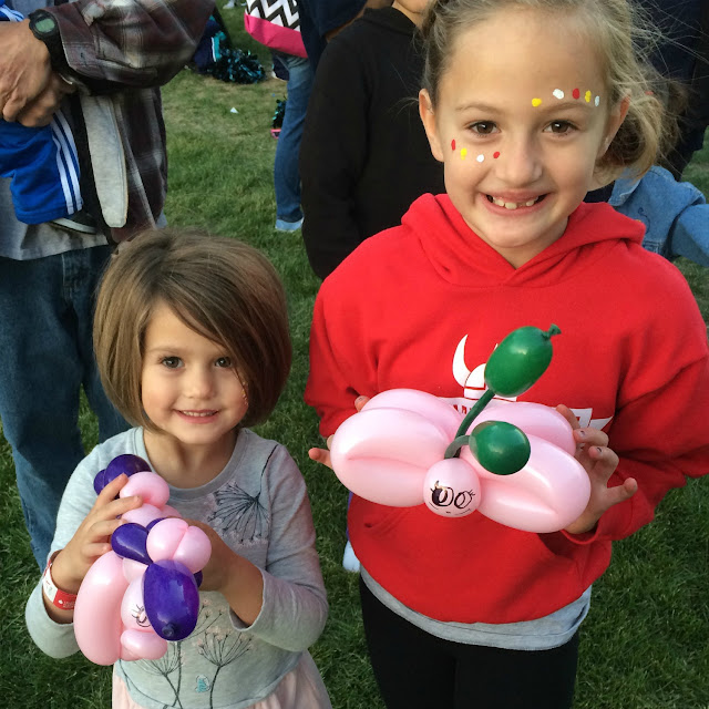 A couple of young sisters posing with thier balloon butterfly and unicorn