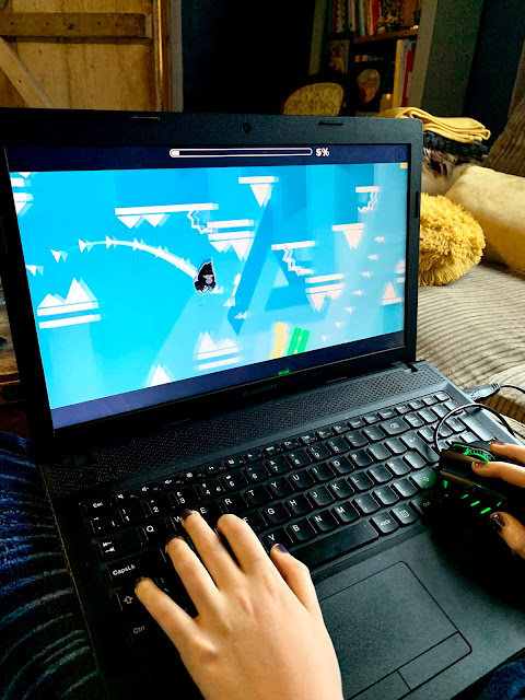 boy playing Geometry Dash on laptop