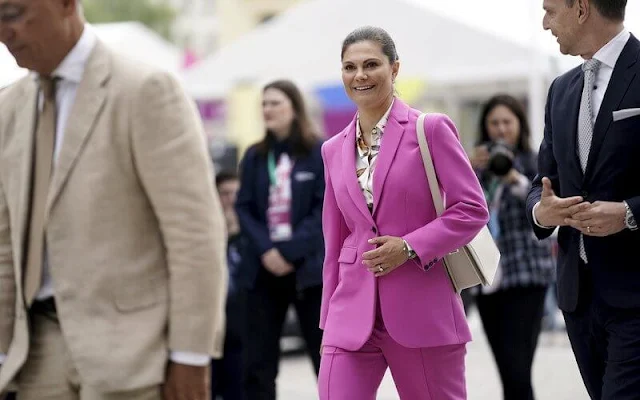 Silvia and Victoria attended the opening of H22 City Expo. Crown Princess Victoria wore a one button blazer suit pink fuchsia