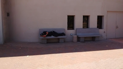 Man Sleeping On Concrete Bench