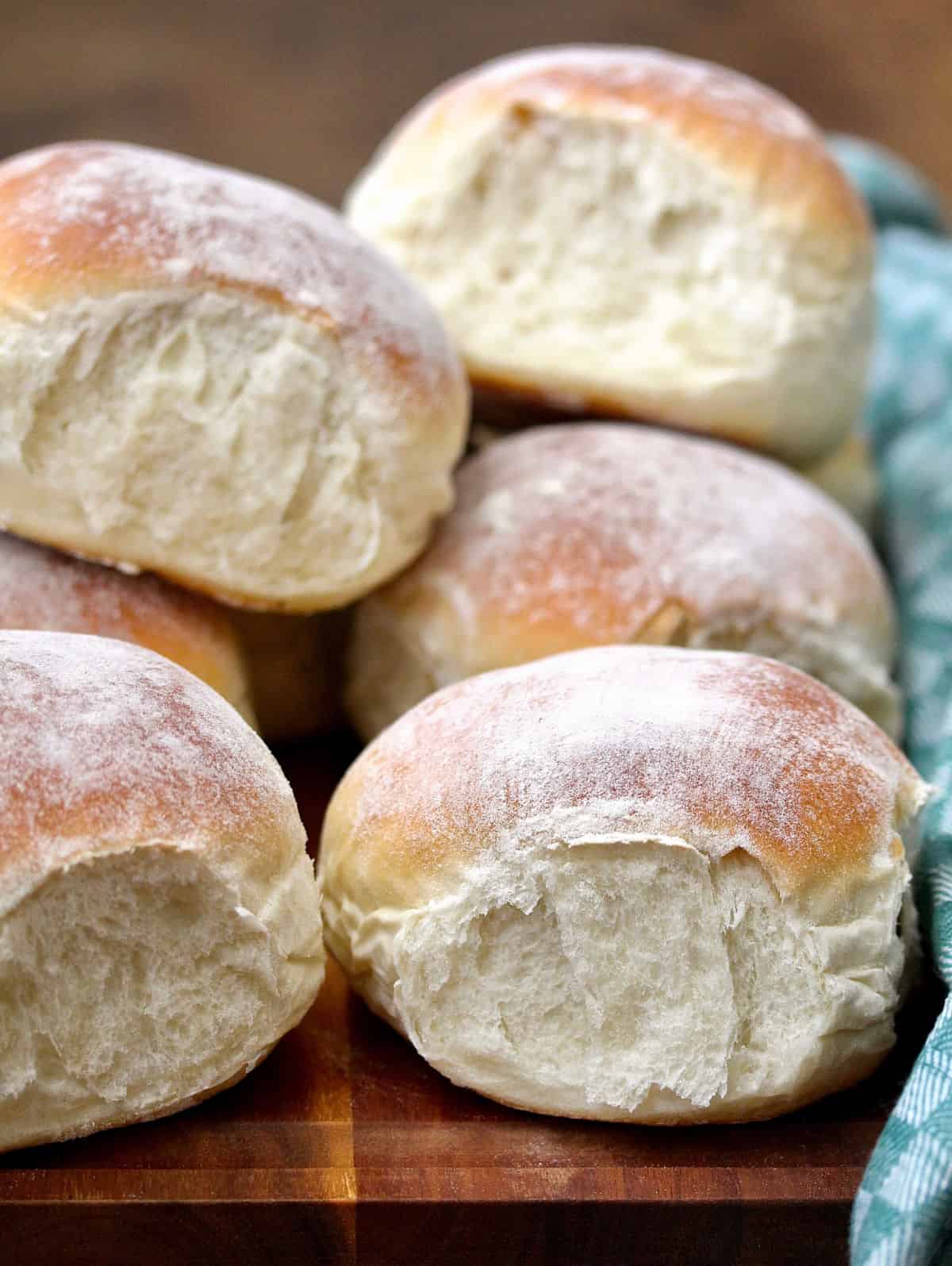 Waterford Blaa rolls stacked on a brown wooden board.