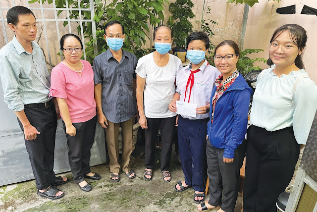 Đại diện UBND Phường 12 trao học bổng cho em  Trần Vinh Quyền. (Ảnh: Mai Trâm)
