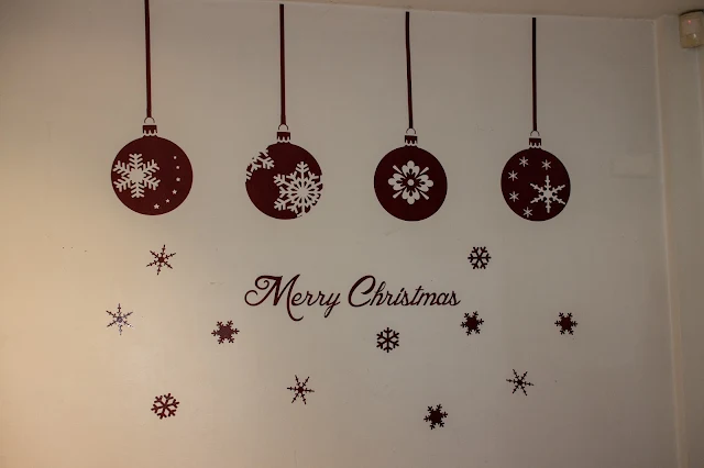 Burgundy wall sticker consisting of 4 large baubles hanging from the ceiling, Merry Christmas and some snowflakes