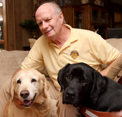 Golden Galleon and black Lab Brinkley by the side of Larry Marcum