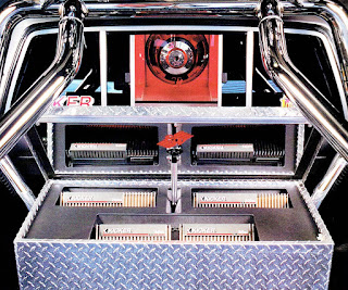 picture of the back of John Stubbs in front of his 1993 Toyota 4x4, with motorized back window open and motorized amp rack open