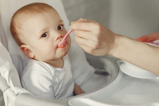 Bayi bahagia menerima makanan dari sendok