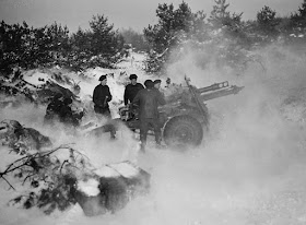 Gunners of the 2nd Heavy Anti-Aircraft Regiment, Royal Canadian Artillery, pushing a 3.7-inch (9.84 cm) anti-aircraft gun through mud. Dunkerque, France, February 1, 1945