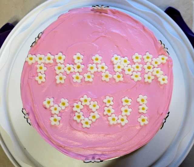 Pink Cake Decorated with Fondant Daisies - Overhead View Showing 'THANK YOU' Spelled out in Tiny Daisies