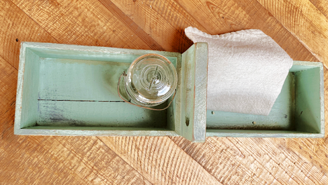green farmhouse crate with towel and jar