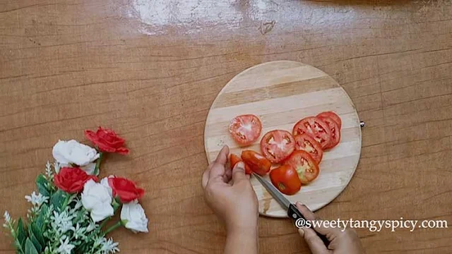 Ripe tomatoes being washed thoroughly and sliced into even rounds. The cook's careful attention ensures uniformity in size and shape for a well-balanced Caprese salad. If using cherry tomatoes, they can be halved or left whole, adding visual appeal to the dish. The vibrant colors and enticing textures promise a delightful culinary experience, celebrating the freshness of the ingredients in this classic Italian salad.