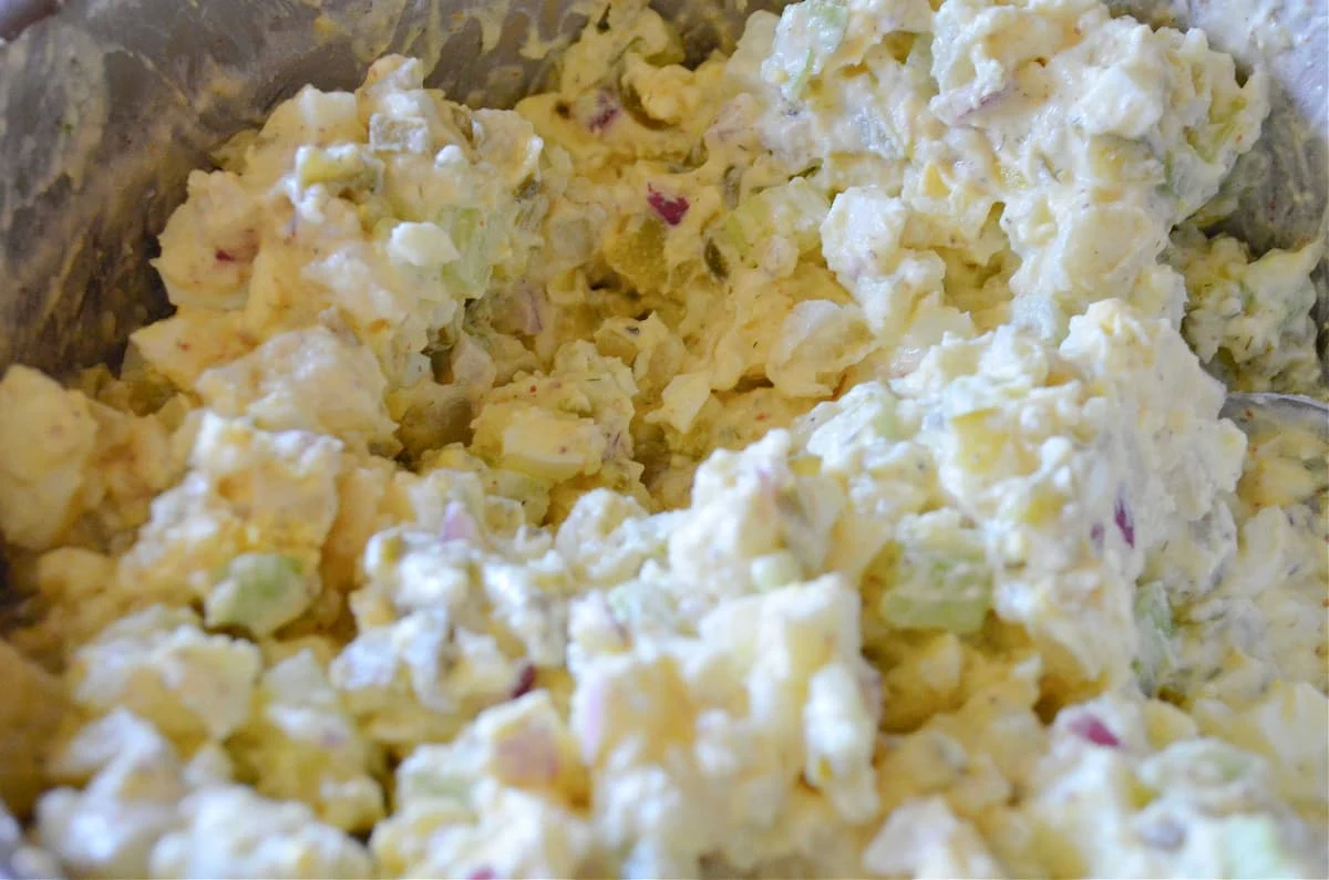 Dill Potato Salad mixed together in a large stainless steel bowl.