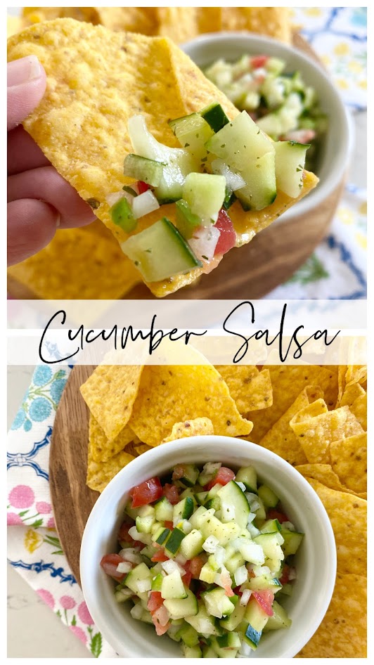 Hand holding tortilla chip with cucumber salsa on it.