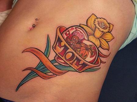A girl showing a tattoo on her belly of a yellow flower and a red heart