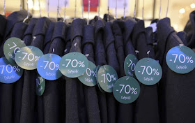 Vêtements étiquetés sur cintres et portants pour être vendus pendant les soldes