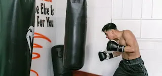 build endurance: Man using a punching bag to practice boxing